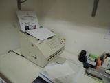 a printer sitting on top of a counter next to a phone