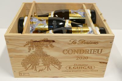 des bouteilles de vin se trouvent dans un coffret en bois sur une table