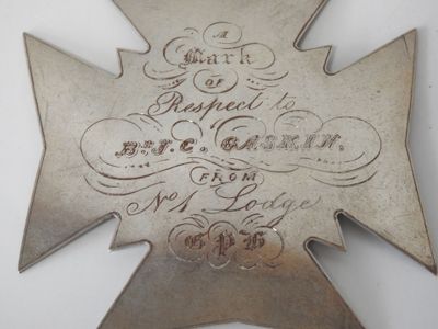 a metal cross with writing on it on a table