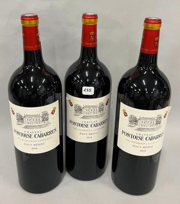 trois bouteilles de vin rouge sont alignées sur une surface blanche