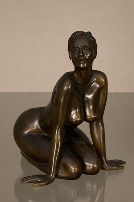 statue en bronze représentant une femme assise par terre, les mains posées sur les genoux