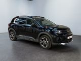 the black suv is parked in a white room with a black floor