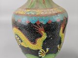 a vase with a dragon painted on it sitting on a table