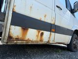 a rusted van parked on the side of the road