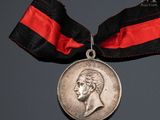 an image of a medal with a ribbon around it and a coin on a table