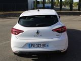 the rear end of a white car parked in a parking lot