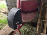 a cement mixer sitting next to a pallet of wood