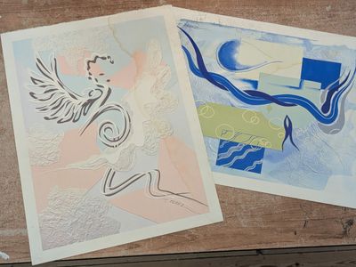 two prints on a wooden table one is a woman and the other is an angel