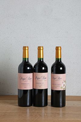 three bottles of wine sitting on top of a wooden table