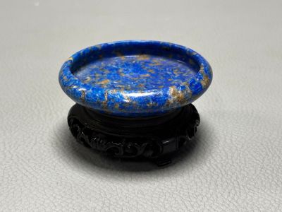 un gros plan d'un petit bol bleu posé sur un socle noir