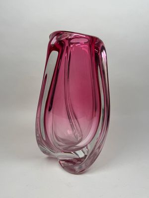 vase en verre violet muni d'une anse incurvée sur un fond blanc