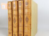 three books are stacked on top of each other on a white surface