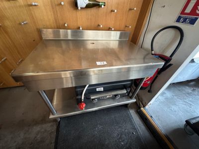 une table de travail en acier inoxydable munie d'une poignée rouge