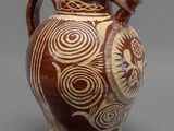 vase marron et blanc orné de motifs en spirale sur fond gris