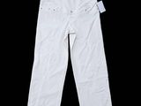 Le pantalon est blanc et comporte des boutons sur le côté.