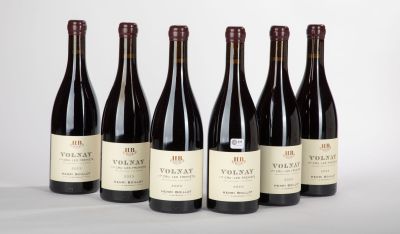 six bouteilles de vin sont alignées sur une table