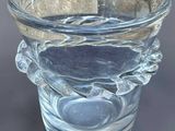 un vase en verre transparent orné d'un motif de feuilles