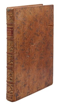 un vieux livre à la couverture brune posé sur une surface blanche