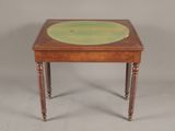 a small table with a green glass top and wooden legs