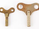 two old keys that are on a white surface