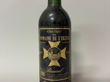 une vieille bouteille de vin posée sur une table blanche