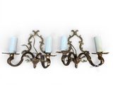 four candle holders are hanging on a wall in a row