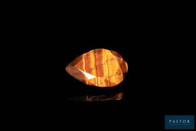 a close up of a yellow tiger eye stone on a black surface