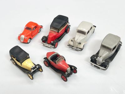plusieurs petites voitures sont alignées sur une surface blanche