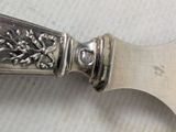 a silver spoon with a flower on it on a table