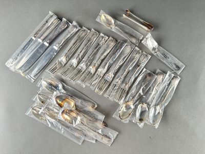 a lot of silverware in plastic bags on a table