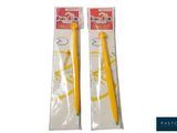 deux brosses à dents jaunes dans des sachets en plastique sur fond blanc