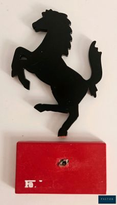 un cheval noir debout sur ses pattes arrière, perché sur une boîte rouge