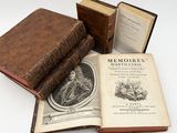three old books sitting on top of each other on a table