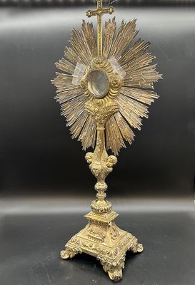 un crucifix plaqué or, surmonté d'une croix, posé sur une table