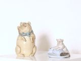 deux figurines de chats posées l'une à côté de l'autre sur une étagère