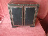 a small black cabinet with two doors on top of it