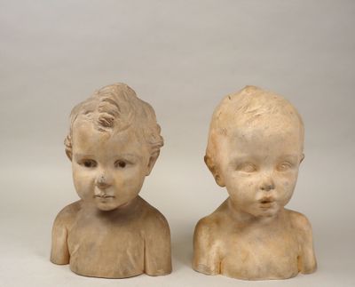 paire de têtes sculptées dans la pierre représentant un garçon et une fille, sur fond blanc