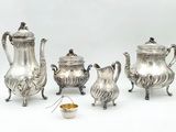 a silver tea set on a white background with a bowl