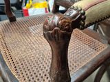 a wooden chair with a brown seat and arm rest