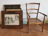 une chaise et un tableau posé par terre à côté d'une chaise