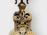 a gold vase on a stand with two birds on it