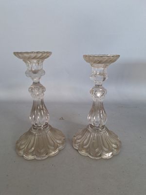 deux bougeoirs en verre transparent posés sur une table