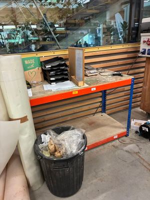 une poubelle posée devant une vitrine de magasin