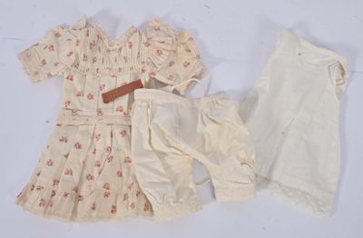 une image représentant la robe et le short d'une poupée posés sur une surface blanche