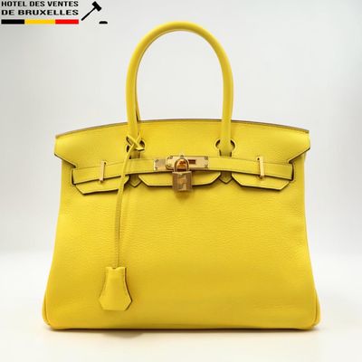 un sac à main en cuir jaune sur fond blanc