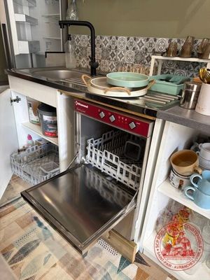 un lave-vaisselle au milieu d'une cuisine, avec de la vaisselle à l'intérieur