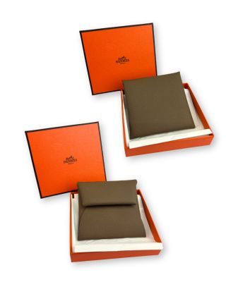 deux boîtes marron et blanches contenant chacune un portefeuille marron