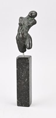 sculpture représentant une tête de chien sur un bloc de marbre noir, sur fond blanc