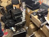 a pile of computers and other electronic equipment in a room