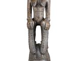 an old wooden statue of a man sitting on top of a head